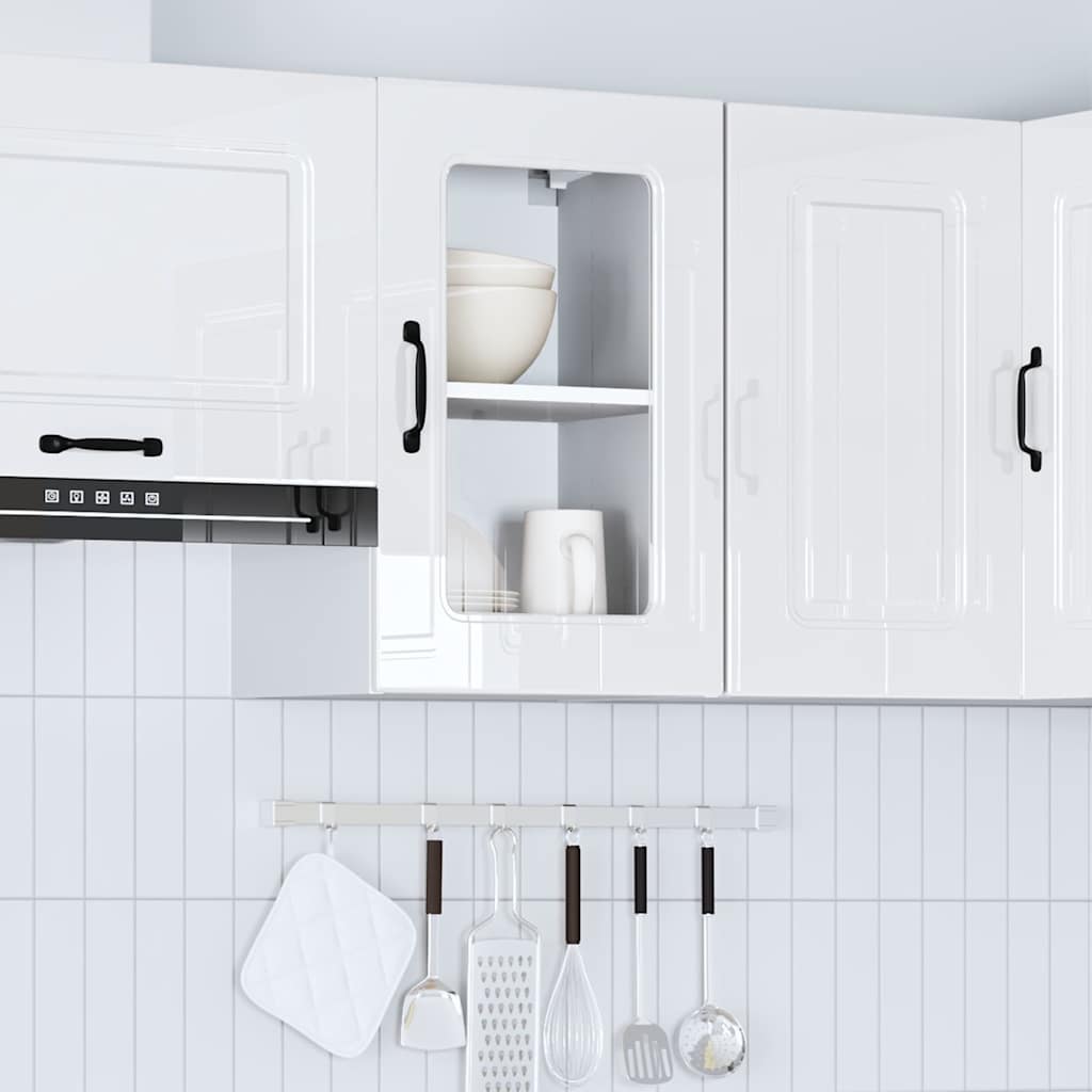 White kitchen wall cabinets with glass doors and black handles above a tiled backsplash