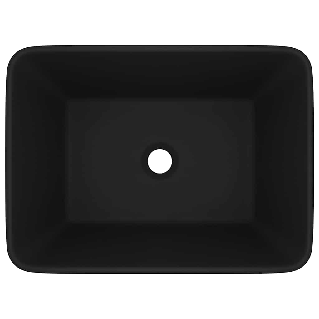 Top view of a matt black ceramic wash basin showing the drain hole