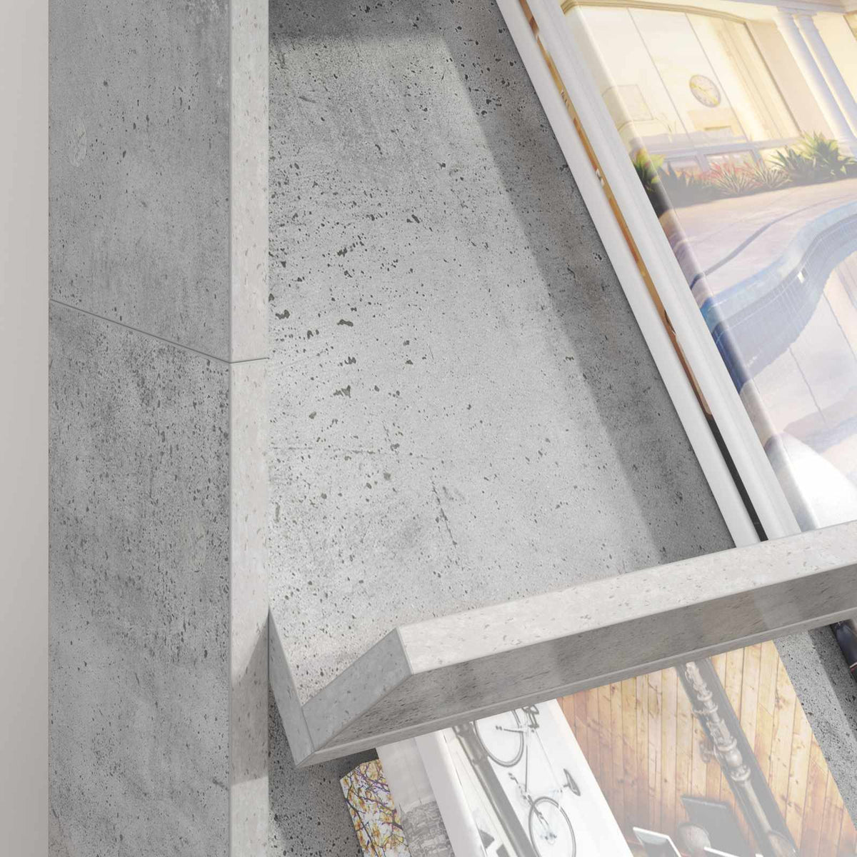 Close-up of the slanted shelves of the concrete grey magazine rack, showing magazine covers