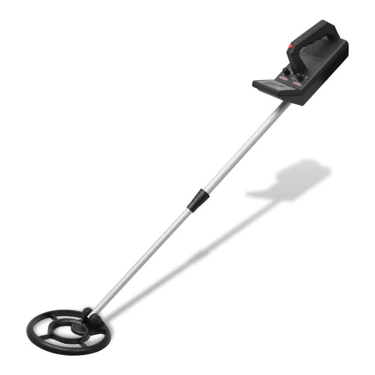 The metal detector with shovel is shown from a side angle, with the coil on the ground