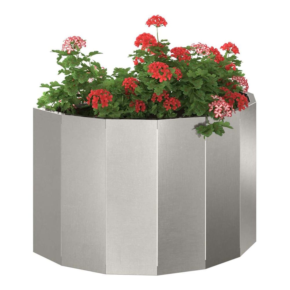 A silver stainless steel planter filled with red flowers on a patio
