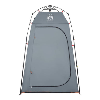 The grey privacy tent with its door zipped closed, showing the full exterior