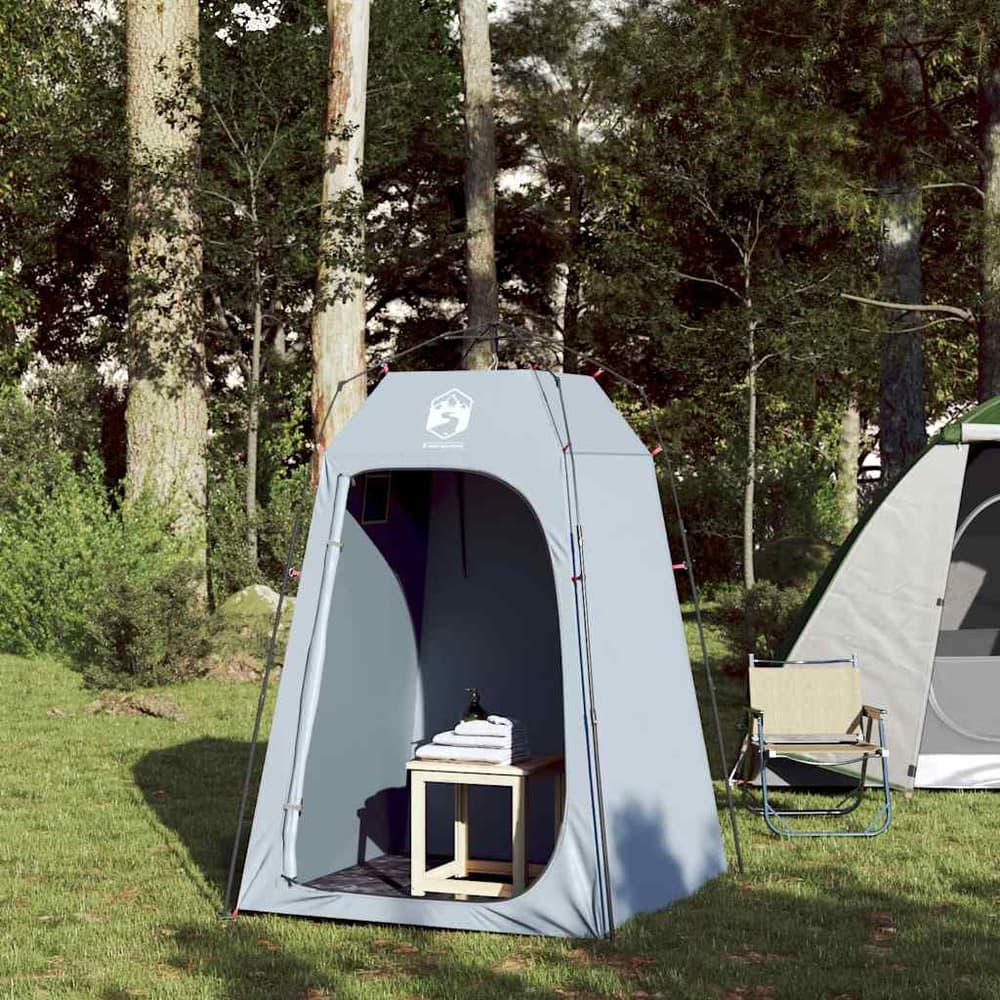 The grey privacy tent with the door open, a chair and table visible inside