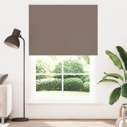 vidaXL Roller Blind Blackout Coffee hanging in a window with a lamp and plant beside it