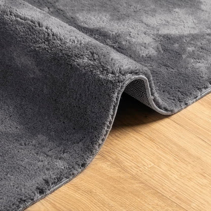 curled corner of the anthracite rug showing the texture and backing