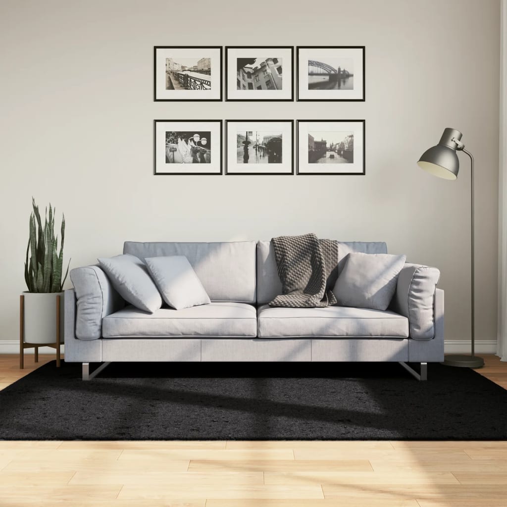 vidaXL Rug OVIEDO Short Pile Black 140x200 cm on a wooden floor in a living room setting