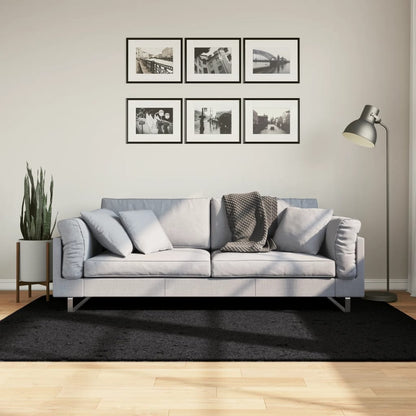 vidaXL Rug OVIEDO Short Pile Black 140x200 cm on a wooden floor in a living room setting