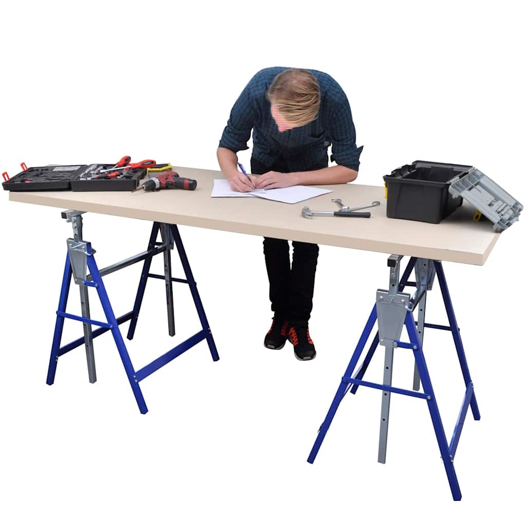 A man works at a table supported by two scaffolding trestles, with tools laid out