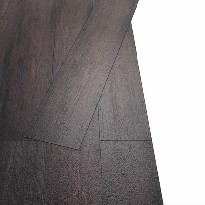 Two dark brown self-adhesive flooring planks laid together showing the join