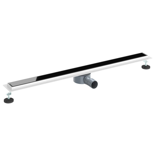 The shower drain with a black glass cover and adjustable feet, showing the siphon connection