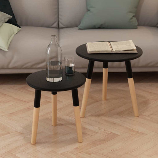 Side Table Set 2 Pieces Solid Pinewood Black in a living room setting with a bottle and book on top