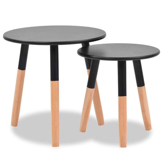 Two black round side tables with natural wood legs, one slightly taller than the other