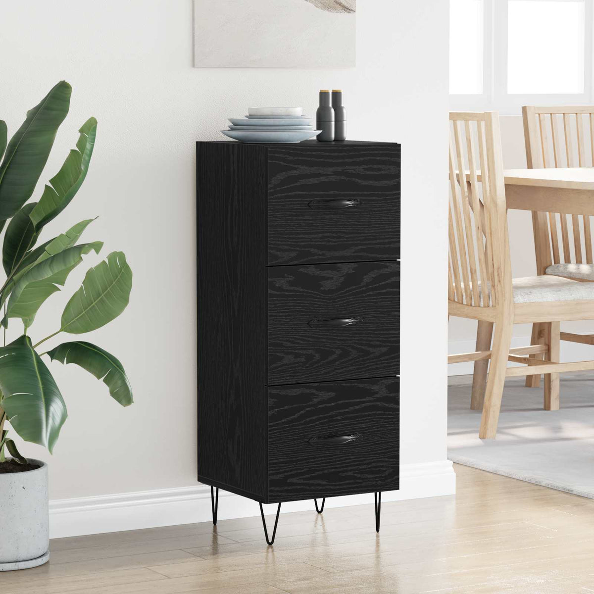 The black oak sideboard with three drawers and thin metal legs, shown in a room setting