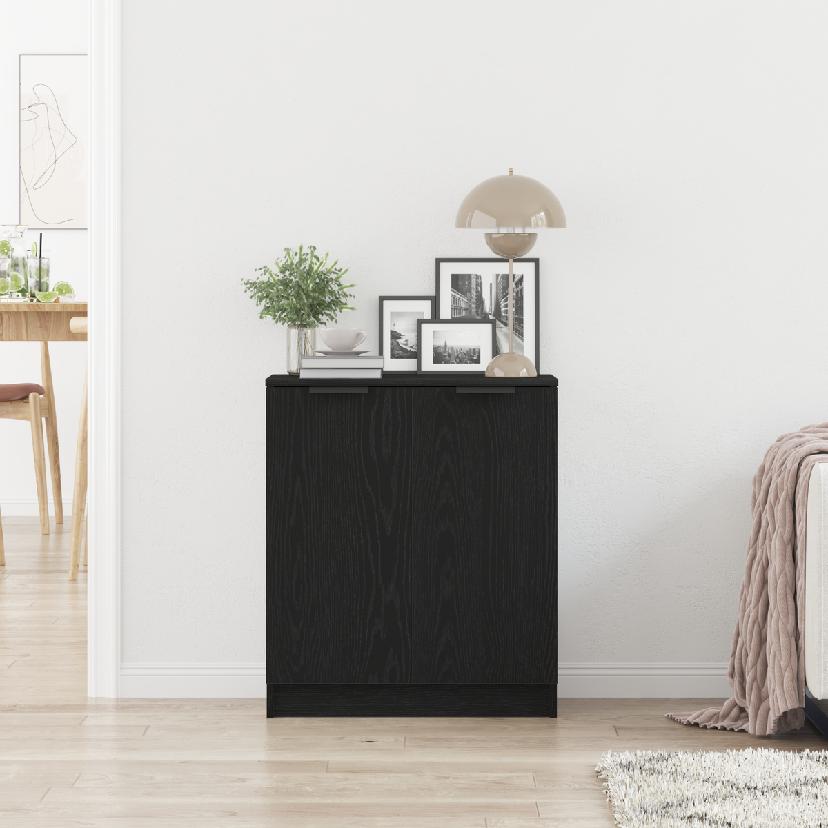 The black sideboard positioned in a bright room with home accessories