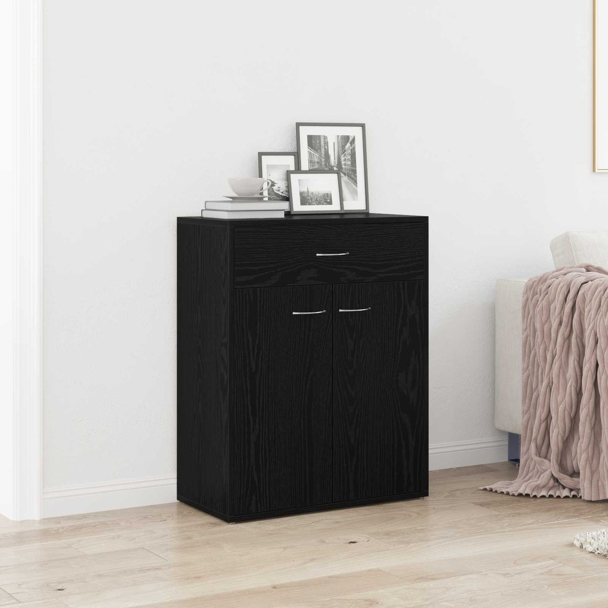 The black sideboard decorated with picture frames in a modern living room