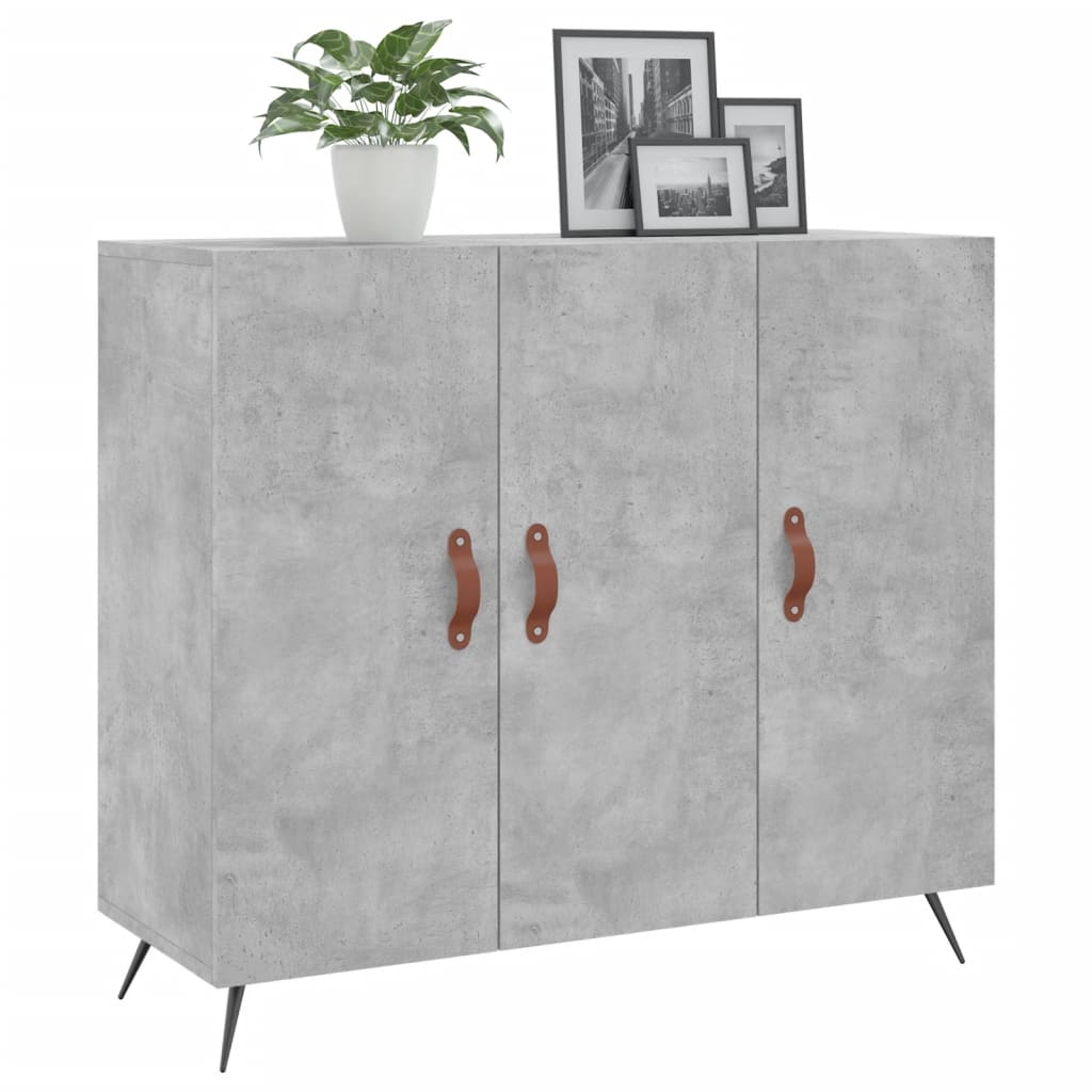 Sideboard with concrete grey finish and brown handles, topped with a plant and framed pictures