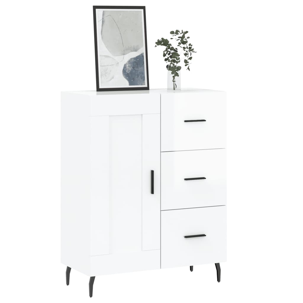 The white sideboard topped with a framed picture and a small plant in a glass vase