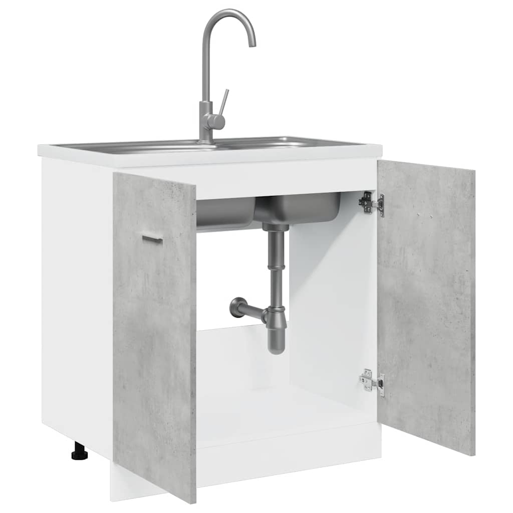 The sink base cabinet with its doors open showing the sink and plumbing