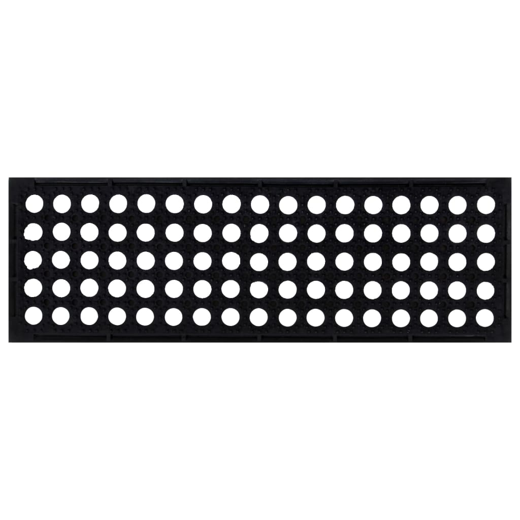 Close-up of the textured surface of a black rubber stair tread with circular perforations
