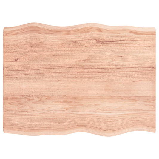 The light brown solid wood oak live edge table top showing its natural wavy edge