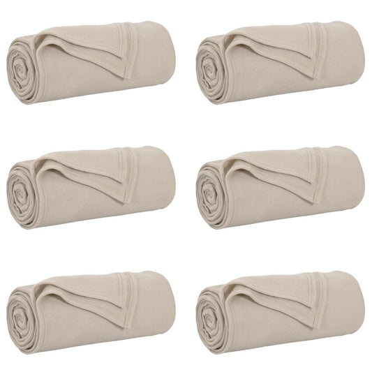 The beige blankets arranged in a grid of six individual rolls against a plain white background