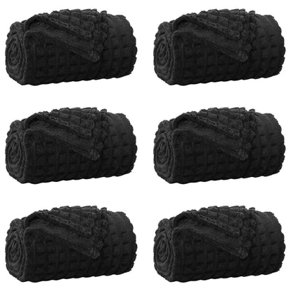 Six rolled up black fleece blankets arranged in two rows