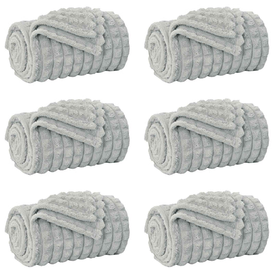 Six grey fleece blankets rolled up and placed side by side
