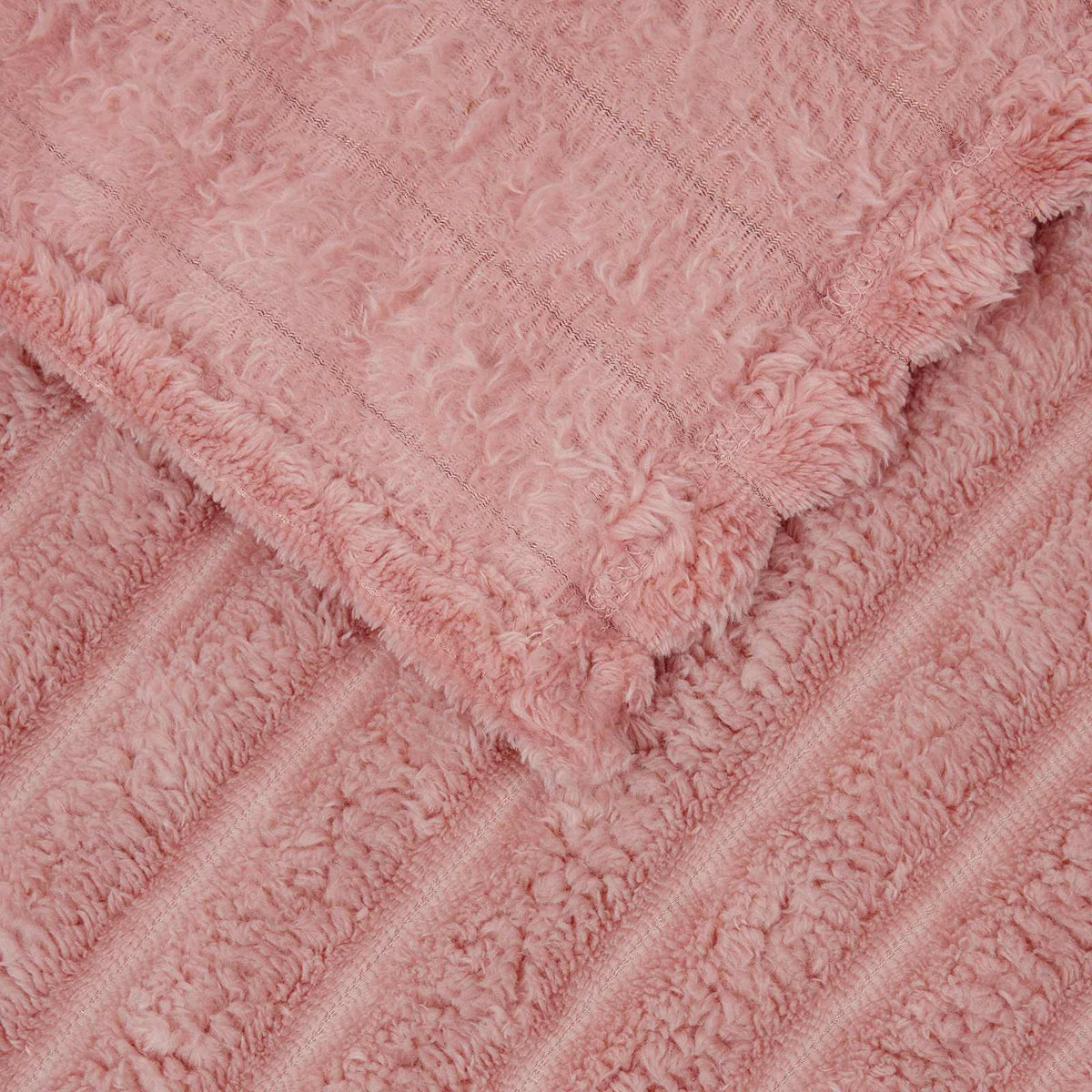 A close-up of the pink fleece blanket showing the soft ribbed fabric and edges