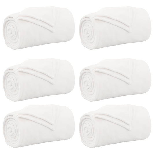 six white fleece blankets rolled up and displayed together