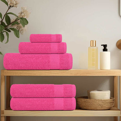 Pink towels arranged on a shelf in a bathroom setting