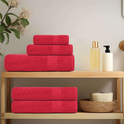the red towels arranged on a wooden bathroom shelf with toiletries and a plant