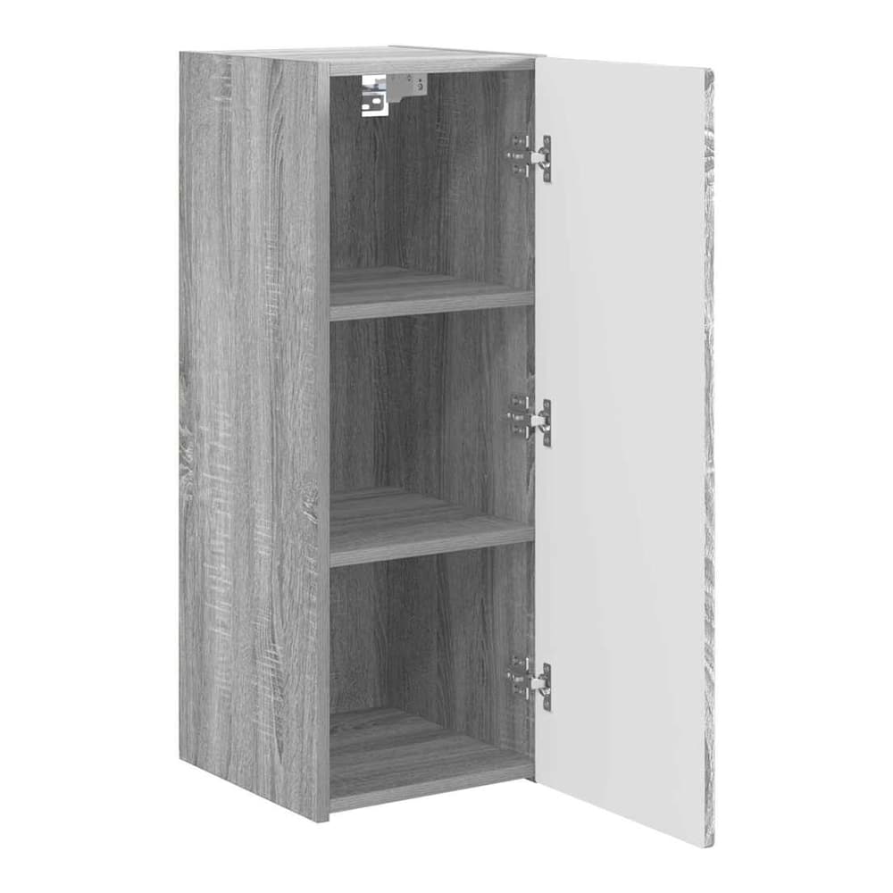 The grey wall cabinet with the door ajar revealing its shelved interior