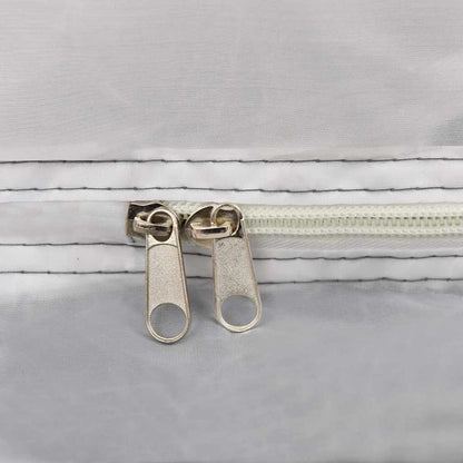 A close-up of the metal zip sliders on the white mesh fabric of the inner tent