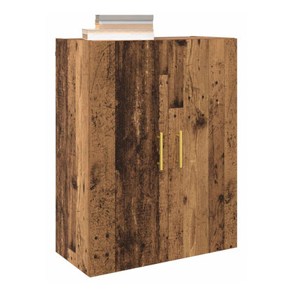 The wooden cabinet with two doors and gold handles, topped with books