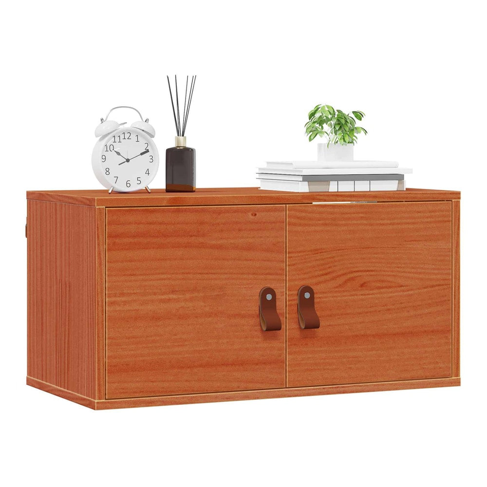 The wall cabinet with its doors closed, showing the wax brown finish and leather handles
