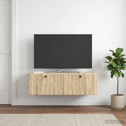 The TV cabinet is mounted on a white wall above a rug with a plant nearby