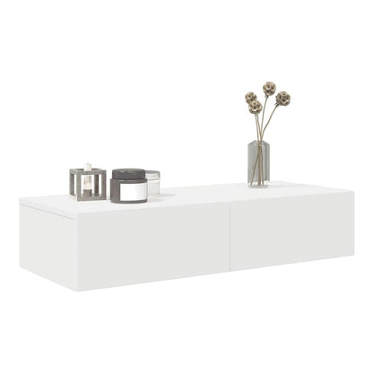 Close-up of the white wall shelf with two drawers and decorative items