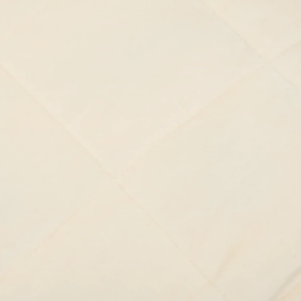 Close up of the light cream fabric of a blanket