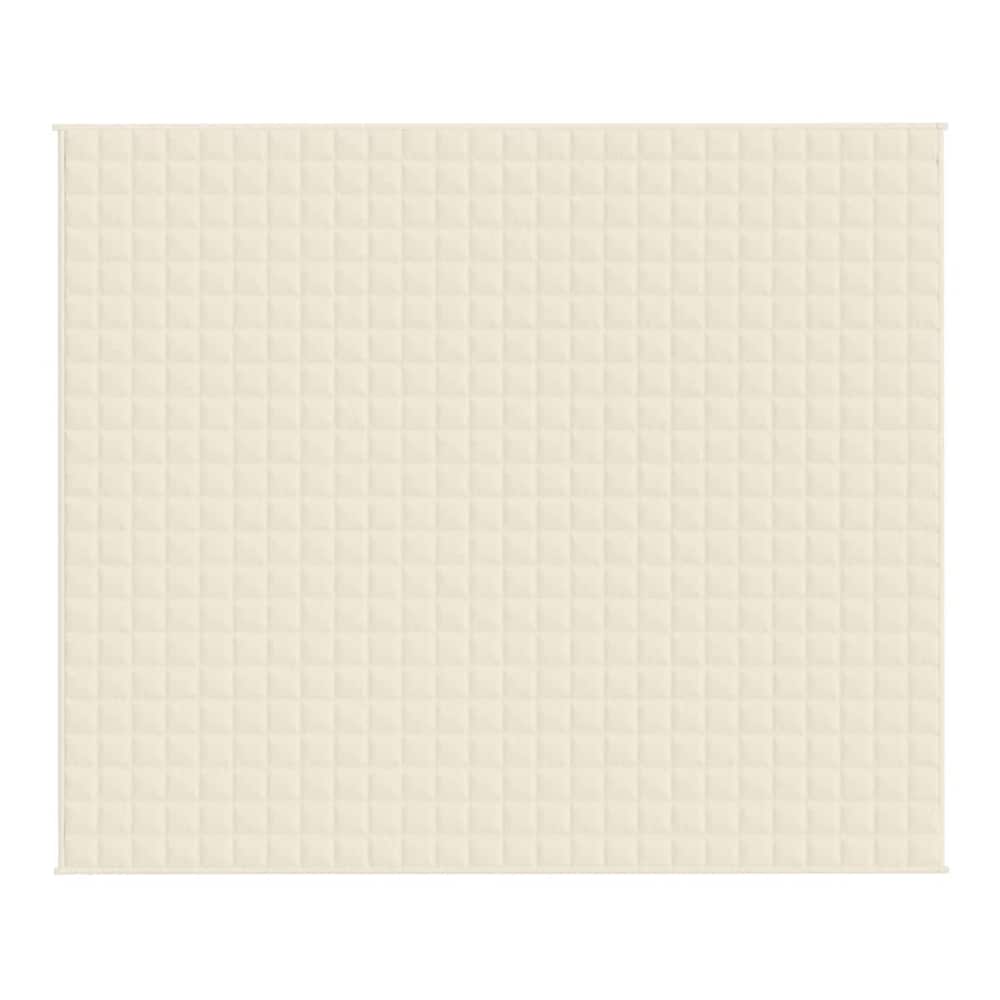 A close-up of the quilted texture of the light cream blanket