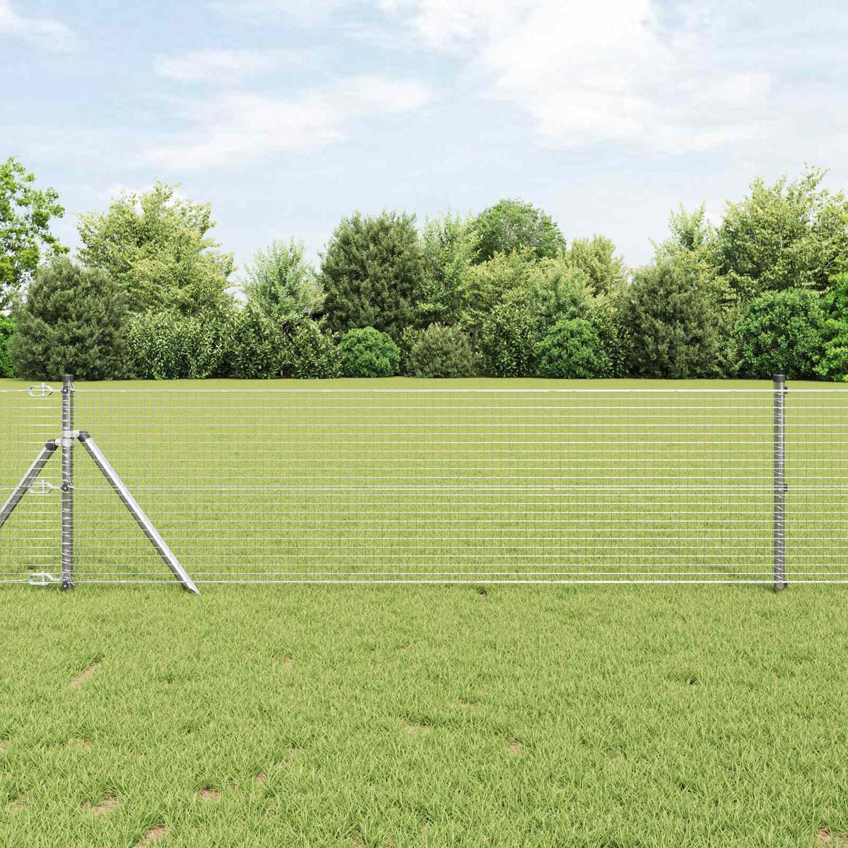 vidaXL Welded Wire Fence Silver set up in a grassy field with trees behind