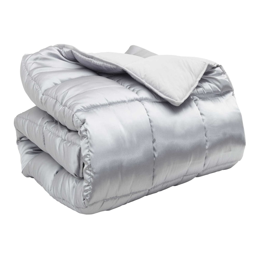 The silver winter duvet folded neatly on a plain background