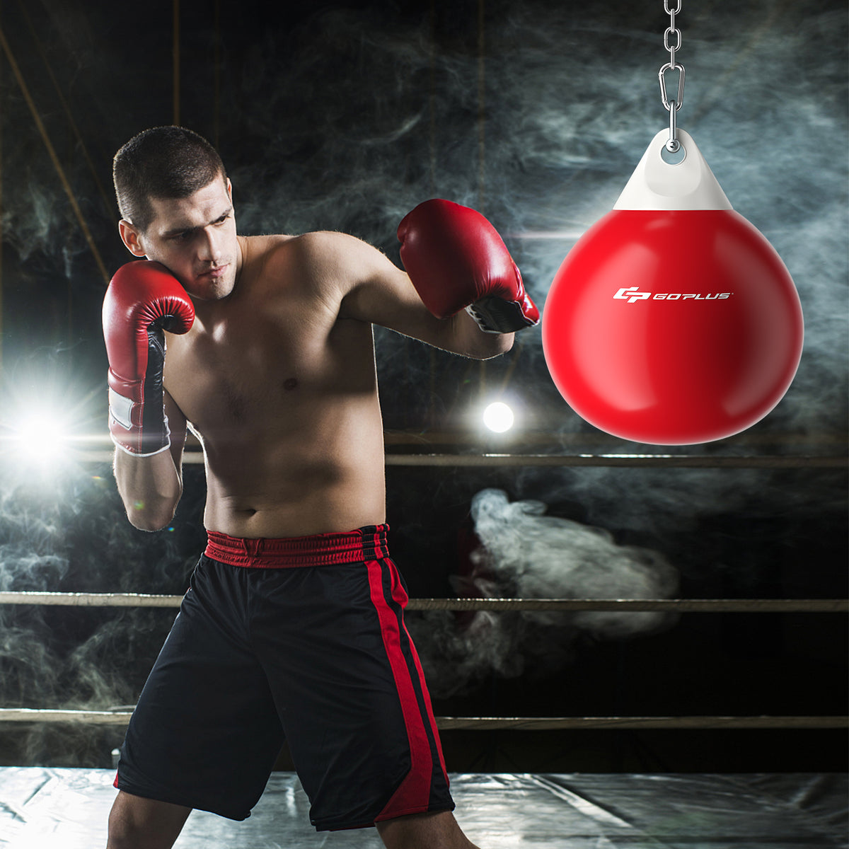 A boxer training with the red water punching bag in a boxing ring