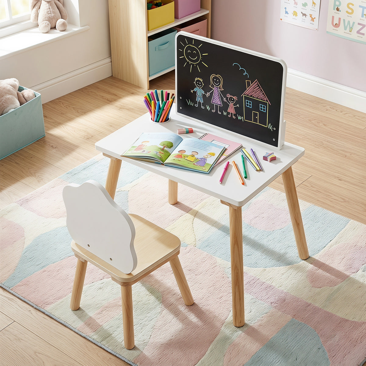 The kids table and chair set with an open book and drawing supplies on the desk