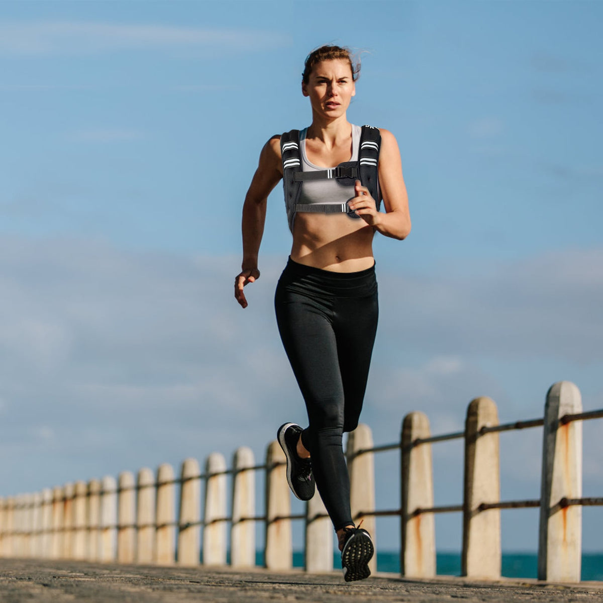 A woman running on a pier wearing the weights accessory with a reflective stripe