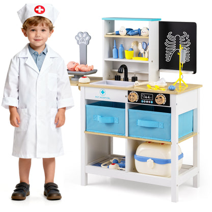 A young boy dressed as a doctor standing next to the wooden medical centre toy set
