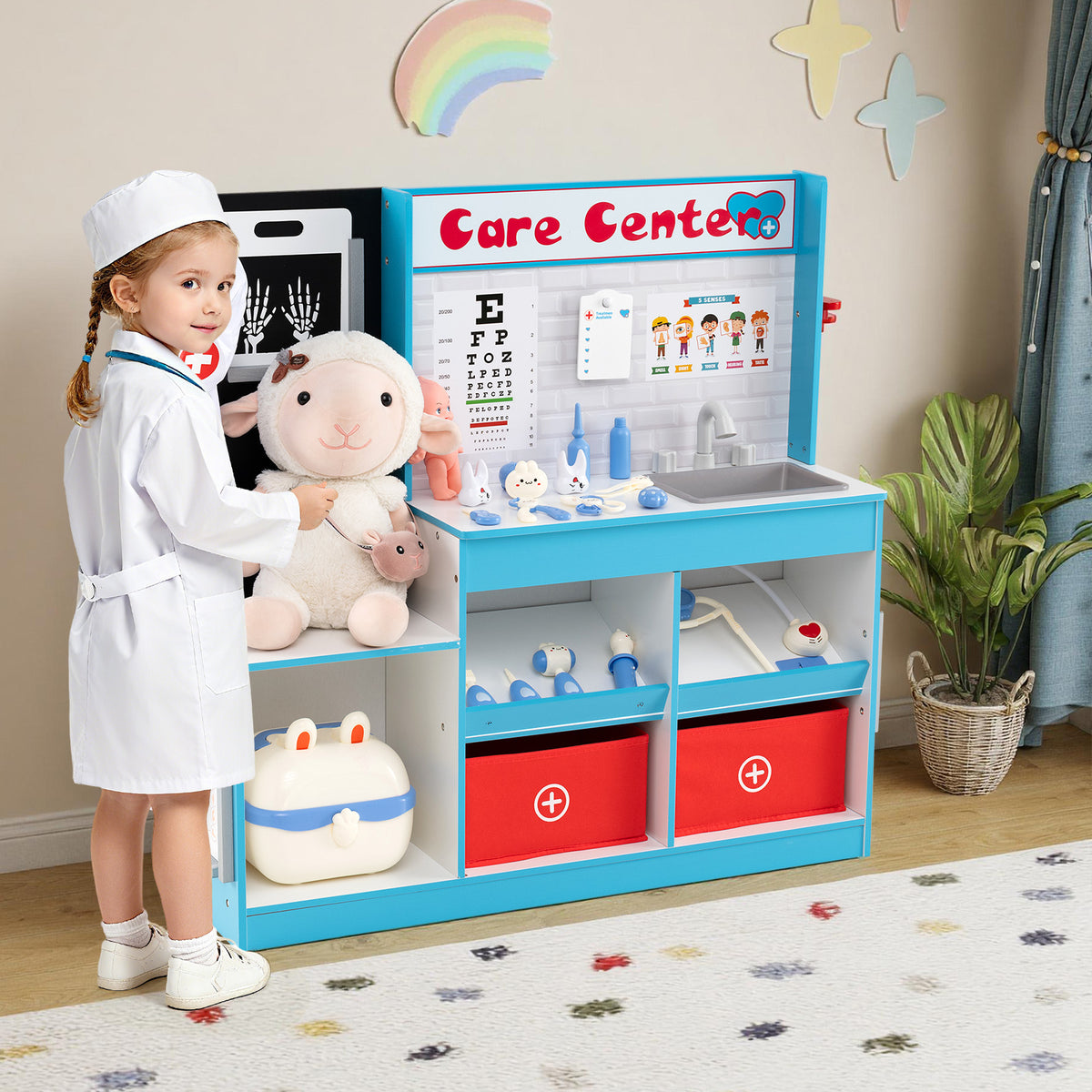 A young girl in a doctor's coat playing with the blue and white medical center toy