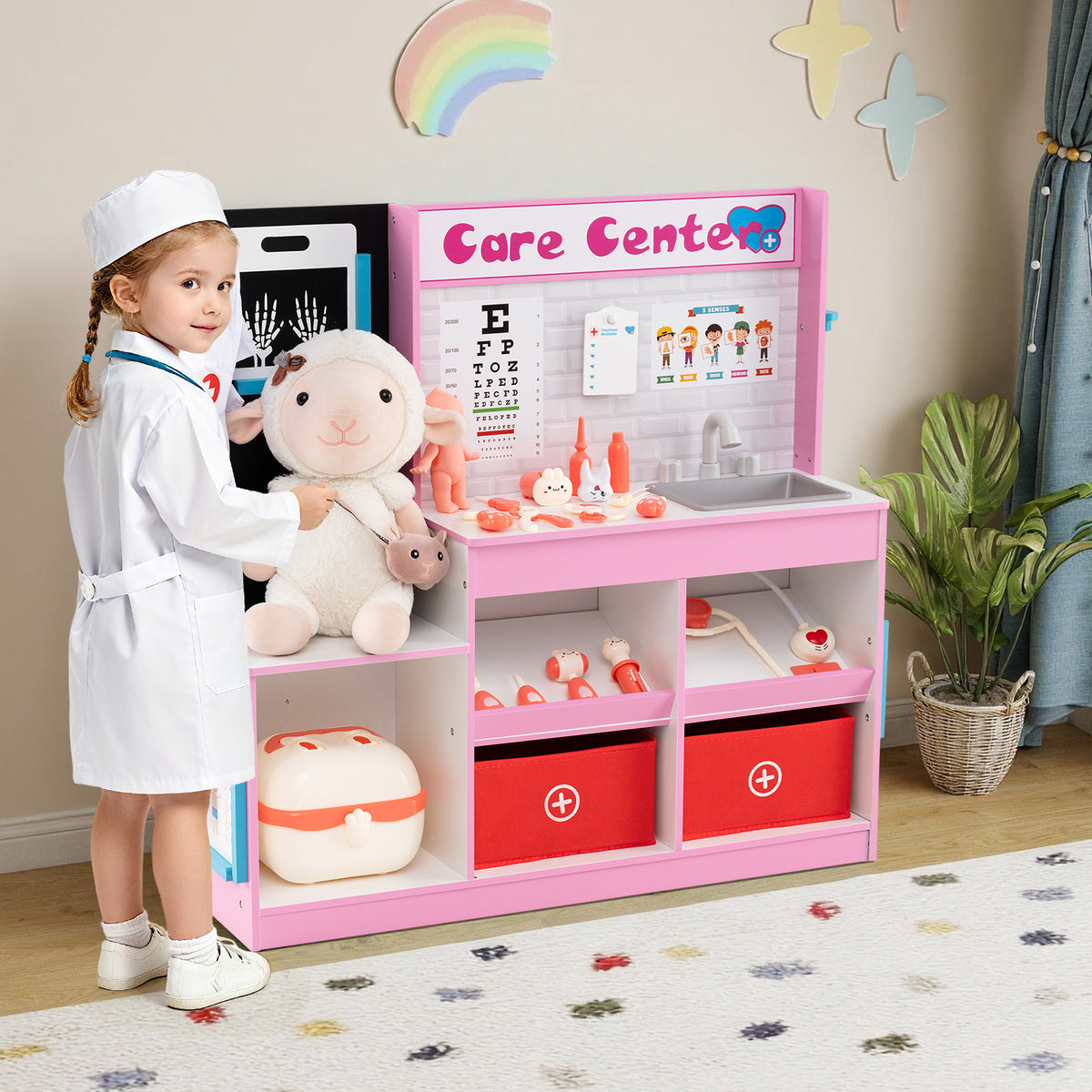 A young child in a doctor's coat playing with the wooden medical centre toy