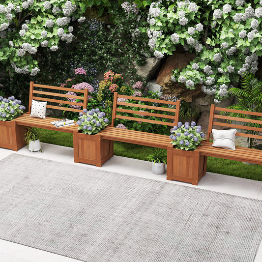 The raised garden beds arranged in a row on a patio with flowers and cushions