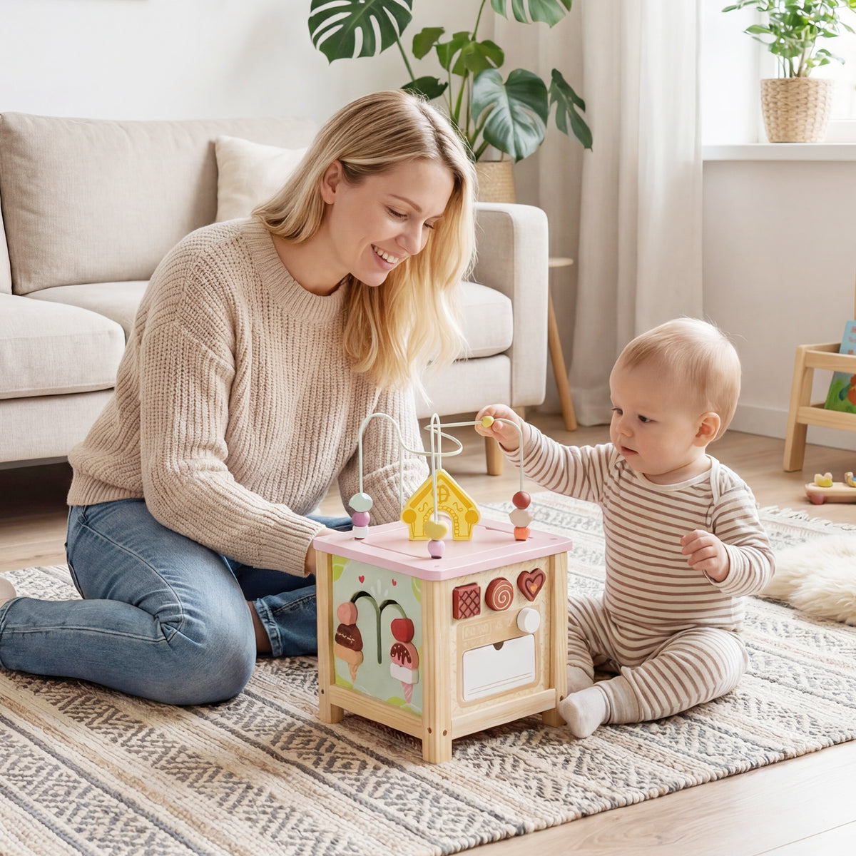 The learning toy being played with by a toddler and a woman in a living room
