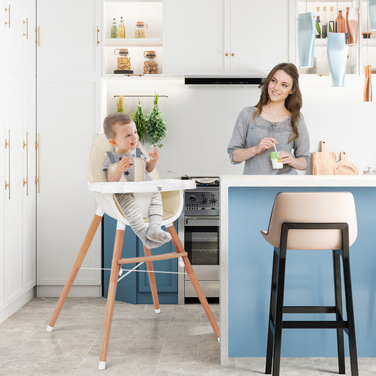 The high chair in a modern kitchen with a toddler sitting in it while a woman stands nearby